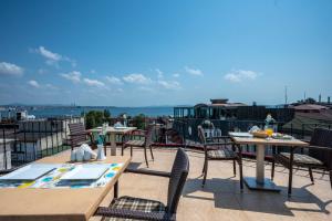 eine Terrasse mit Tischen und Stühlen auf dem Dach in der Unterkunft Osmanhan Hotel in Istanbul
