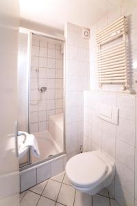 un bagno bianco con wc e doccia di B&B MY PLACE mit Frühstückspaket - with Breakfastbox a Francoforte sul Meno