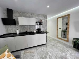 cocina con armarios blancos y lavabo en una habitación en Apartamento Lucano, en Córdoba