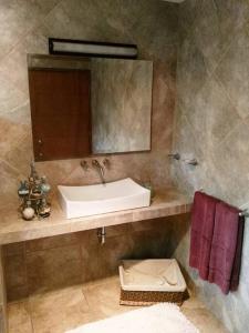 a bathroom with a sink and a mirror at Nice home with gardens and trees, 3 full bedrooms, living and kitchen in León