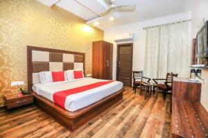 1 dormitorio con 1 cama, mesa y sillas en Hotel Hollywood Heights, en Amritsar