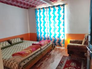 a bedroom with a bed and a window and a couch at Nawang HomeStay in Kaza