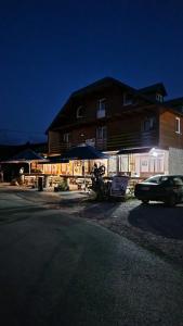 a car parked in front of a building at night at Etno selo - Guest House Etno Village - TRSA in Pluzine