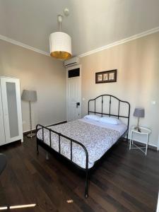 a bedroom with a bed and two tables and a lamp at Suites & Apartments DP VFXira in Vila Franca de Xira
