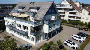an apartment building with a white van parked in a parking lot at FeWo in LA - Ferienwohnung mit 2 Schlafzimmer am Bodensee in Langenargen