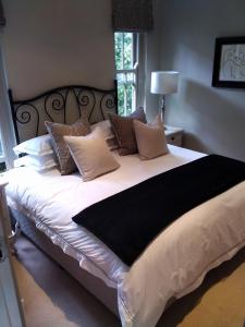 a large bed with brown and white pillows on it at Tranquil Tokai in Tokai