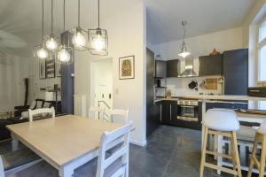 a kitchen and dining room with a table and chairs at Magnificent 2 bedroom duplex + terrace Ixelles in Brussels