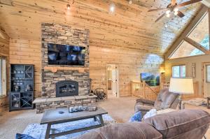 a living room with a stone fireplace in a log cabin at All-Encompassing Cabin with Fire Pit and Kayaks! in Duck Creek Village