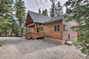 a log cabin with a porch and a flag at All-Encompassing Cabin with Fire Pit and Kayaks! in Duck Creek Village