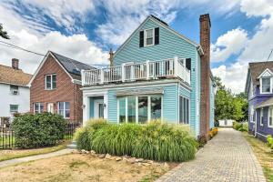 a blue house with a balcony on a street at Walkable New Haven Retreat with Ocean Views! in New Haven