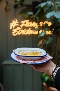 a person holding a plate of food on a plate at Chouchou Hotel in Paris
