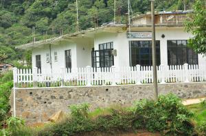a white house with a fence in front of it at Akiko Rest in Nuwara Eliya