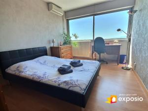 une chambre avec un lit, un bureau et une fenêtre dans l'établissement Bel appartement avec vue splendide sur toute la ville de Colmar - Parking gratuit, à Colmar