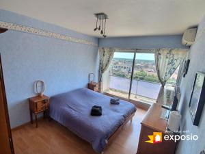 une chambre avec un lit et une grande fenêtre dans l'établissement Bel appartement avec vue splendide sur toute la ville de Colmar - Parking gratuit, à Colmar