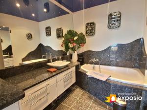 une salle de bain avec une baignoire et un lavabo et une baignoire dans l'établissement Bel appartement avec vue splendide sur toute la ville de Colmar - Parking gratuit, à Colmar