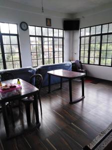 a living room with two tables and a couch at Akiko Rest in Nuwara Eliya