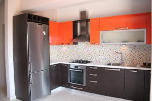 リクスリオンにあるAlekos Beach Houses-Angeloのキッチン(ステンレス製の冷蔵庫、オレンジ色のキャビネット付)