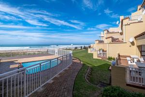 a view of the beach from the balcony of a beach house at Jeffreys Bay Beach Accommodation in Jeffreys Bay