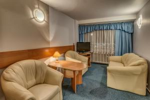a room with two chairs and a table and a tv at Hotel Kujawy in Włocławek