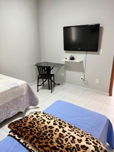 a room with two beds and a table with a television at Casa em ótima localização in Boa Vista +8 photos