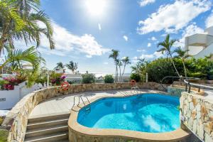 einen Pool in einem Resort mit Palmen in der Unterkunft Apartamentos Garden & Sea Boutique Lodging by LIVVO in Morro del Jable