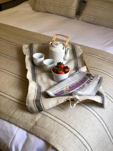 a basket with a newspaper and fruit on a bed at Shining Star, Cartway River Views in Bridgnorth