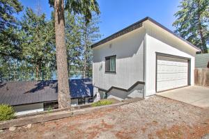 una pequeña casa blanca con garaje en Renovated Hauser Lake Retreat Walk to Beach!, en Hauser