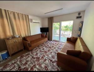 a living room with two couches and a television and a couch at Cıralı müstakil apart in Kemer