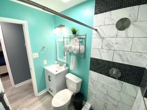 a bathroom with a white toilet and a blue wall at The Great Escape With Friends & Family & Pets!!! in Jacksonville
