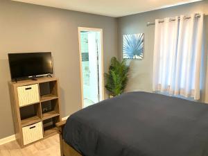 een slaapkamer met een bed en een flatscreen-tv bij The Great Escape With Friends & Family & Pets!!! in Jacksonville