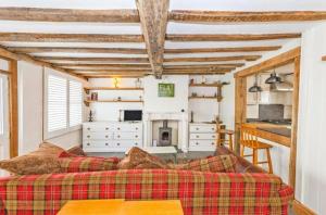ein Wohnzimmer mit einem Sofa und einer Küche in der Unterkunft Samuel Pepys Cottage in Huntingdon