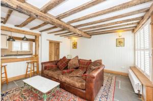 een woonkamer met een bank en een tafel bij Samuel Pepys Cottage in Huntingdon