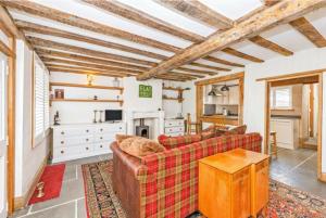 uma sala de estar com um sofá e uma mesa em Samuel Pepys Cottage em Huntingdon