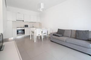 uma sala de estar com um sofá e uma cozinha em Finisterrae 1 em Lido di Jesolo