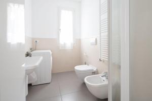 uma casa de banho branca com um WC e um lavatório em Finisterrae 1 em Lido di Jesolo