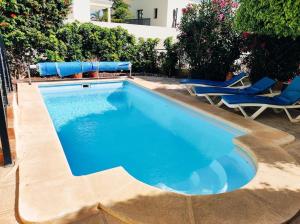 uma piscina com duas cadeiras e uma piscina em Private pool 'Villa Vibe Tenerife' sunset & ocean view em Chayofa