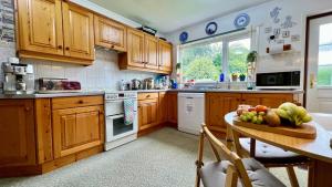 a kitchen with wooden cabinets and a table with fruit on it at Old Captain Guest House in Portree