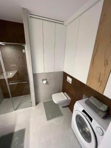 a bathroom with a washing machine and a toilet at Apartamenty Olimpijska 1B & 1T in Szczyrk