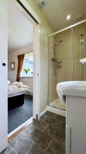 a bathroom with a shower and a sink and a bed at Old Captain Guest House in Portree