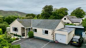 une vue aérienne sur une maison avec un parking dans l'établissement Old Captain Guest House, à Portree