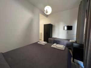 a room with a bed and a couch and a television at Affittacamere Umberto I in Foligno