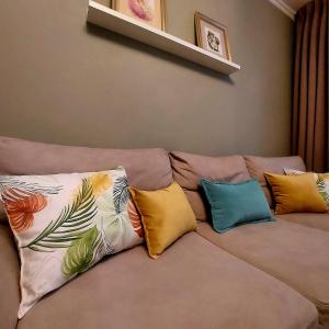 un divano con quattro cuscini colorati sopra di Apartament Marasesti a Piteşti