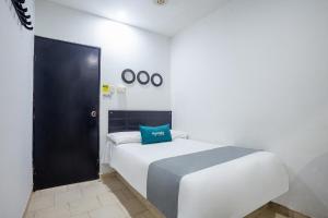 - une chambre avec un lit doté d'un oreiller bleu dans l'établissement Ayenda Hotel Alejandría, à Montería
