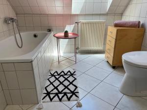 een badkamer met een bad, een toilet en een tafel bij Studio Loft in Pécs