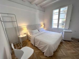 una camera bianca con un letto bianco e una finestra di The MO GOTIC a Barcellona