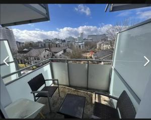 balkon z krzesłami i widokiem na miasto w obiekcie Apartment in München w Monachium