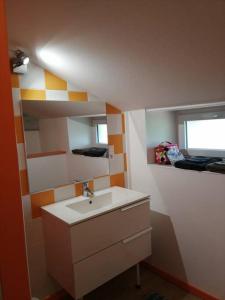 Elle comprend une petite salle de bains pourvue d'un lavabo et d'une fenêtre. dans l'établissement Appartement a la campagne, à Grièges