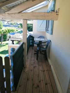 une terrasse en bois avec une table et une table dans l'établissement Appartement a la campagne, à Grièges