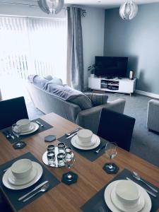 a living room with a table with plates and wine glasses at Cozy & Spacious home In the heart of Snowdonia in Llanddeiniolen