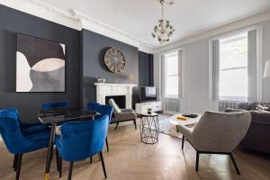 ein Wohnzimmer mit blauen Stühlen und einem Tisch in der Unterkunft Discounted Pure Luxury By Nobu Hotel in London